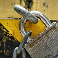 A masterlock chained to a post